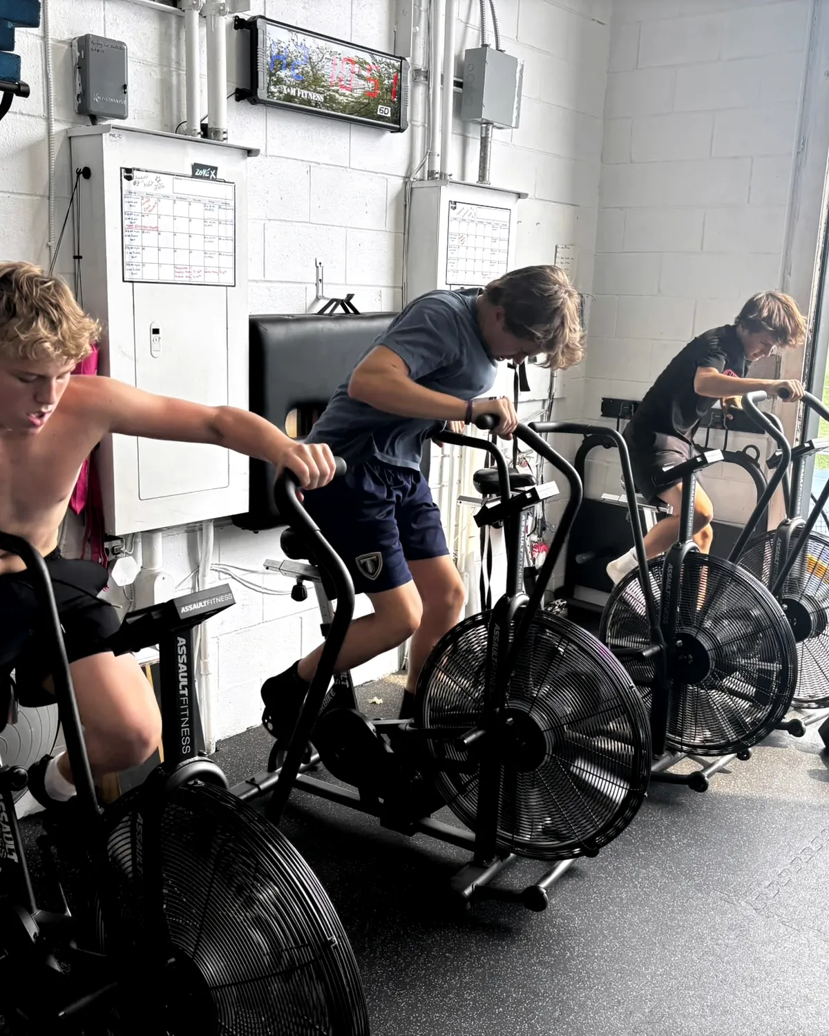 Young athletes on assault bikes