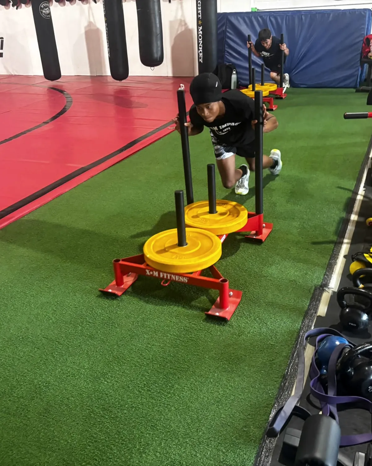 A young athlete pushing a weighted sled